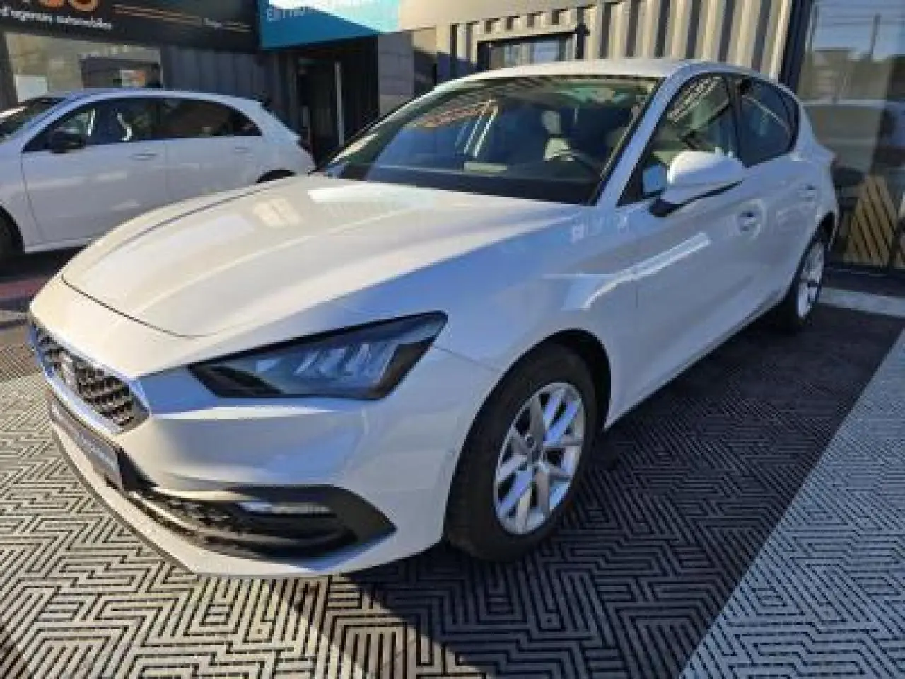 SEAT Leon IV blanche vue en 3/4 avant droit, avec phares LED et jantes alliage 16 pouces.