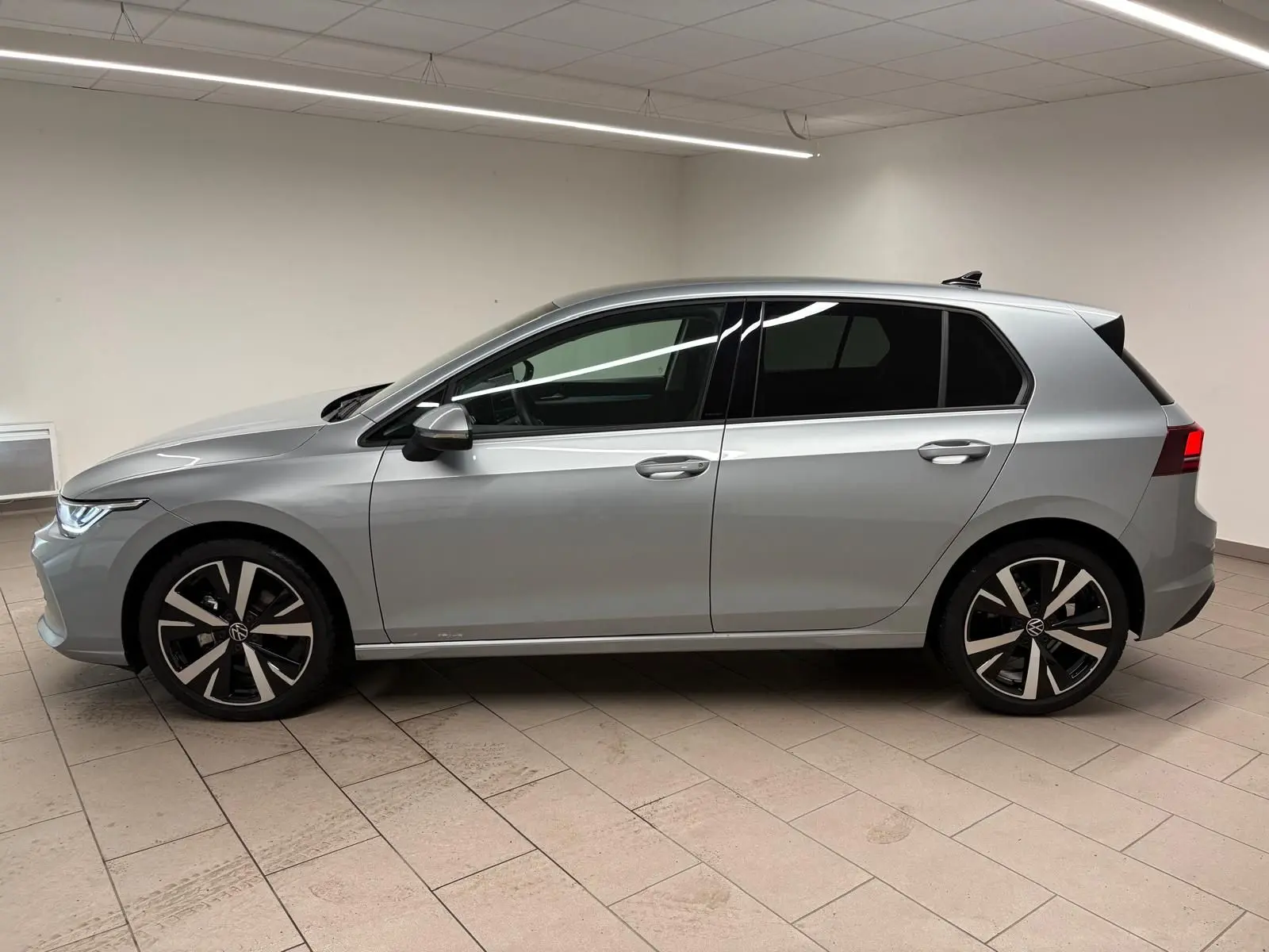 Profil côté gauche d'une Volkswagen Golf 1.5 TSI 2025 en argent Dolomite avec jantes alliage 18 pouces 'Catania'