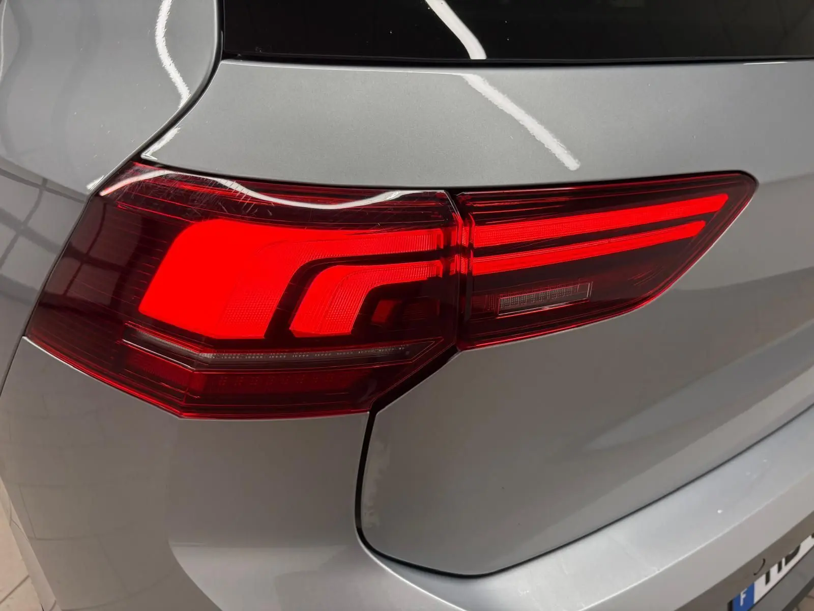 Gros plan sur le feu arrière droit d'une Volkswagen Golf 1.5 TSI 2025 en Argent Dolomite métallisé.