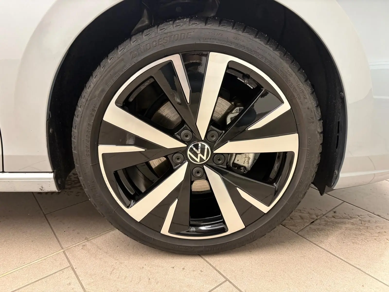 Gros plan sur la jante alliage 18'' Catania bicolore noir et argent de la Volkswagen Golf 1.5 TSI 2025 argent Dolomite.