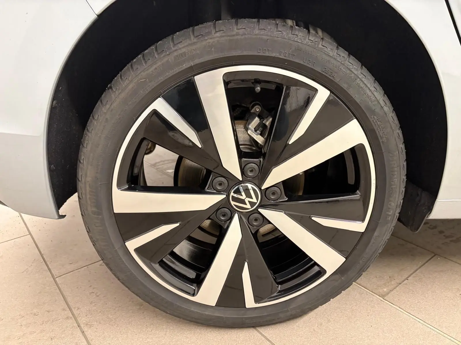 Gros plan sur la jante alliage 18'' Catania noire et argentée de la Volkswagen Golf 1.5 TSI 2025 couleur Argent Dolomite.