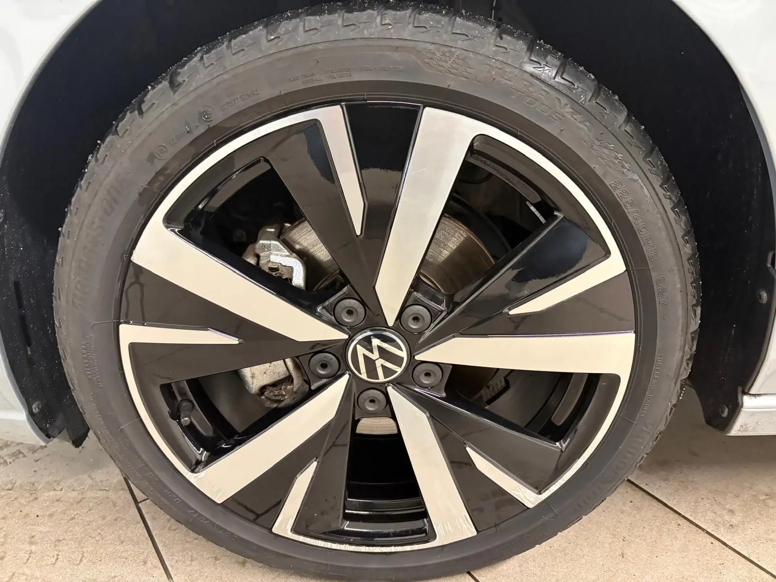 Gros plan sur la jante alliage 18 pouces 'Catania' bicolore noir et argent d'une Volkswagen Golf Argent Dolomite.