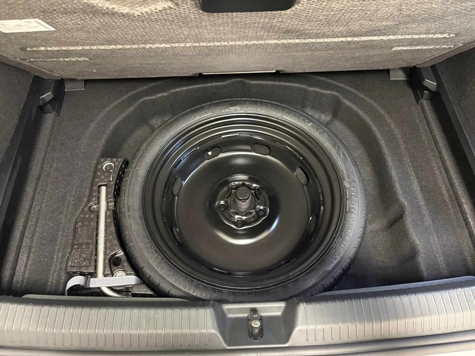 Roue de secours et outillage dans le coffre d'une Volkswagen Golf 1.5 TSI 116 BVM6 VW Edition 2025 argent Dolomite.