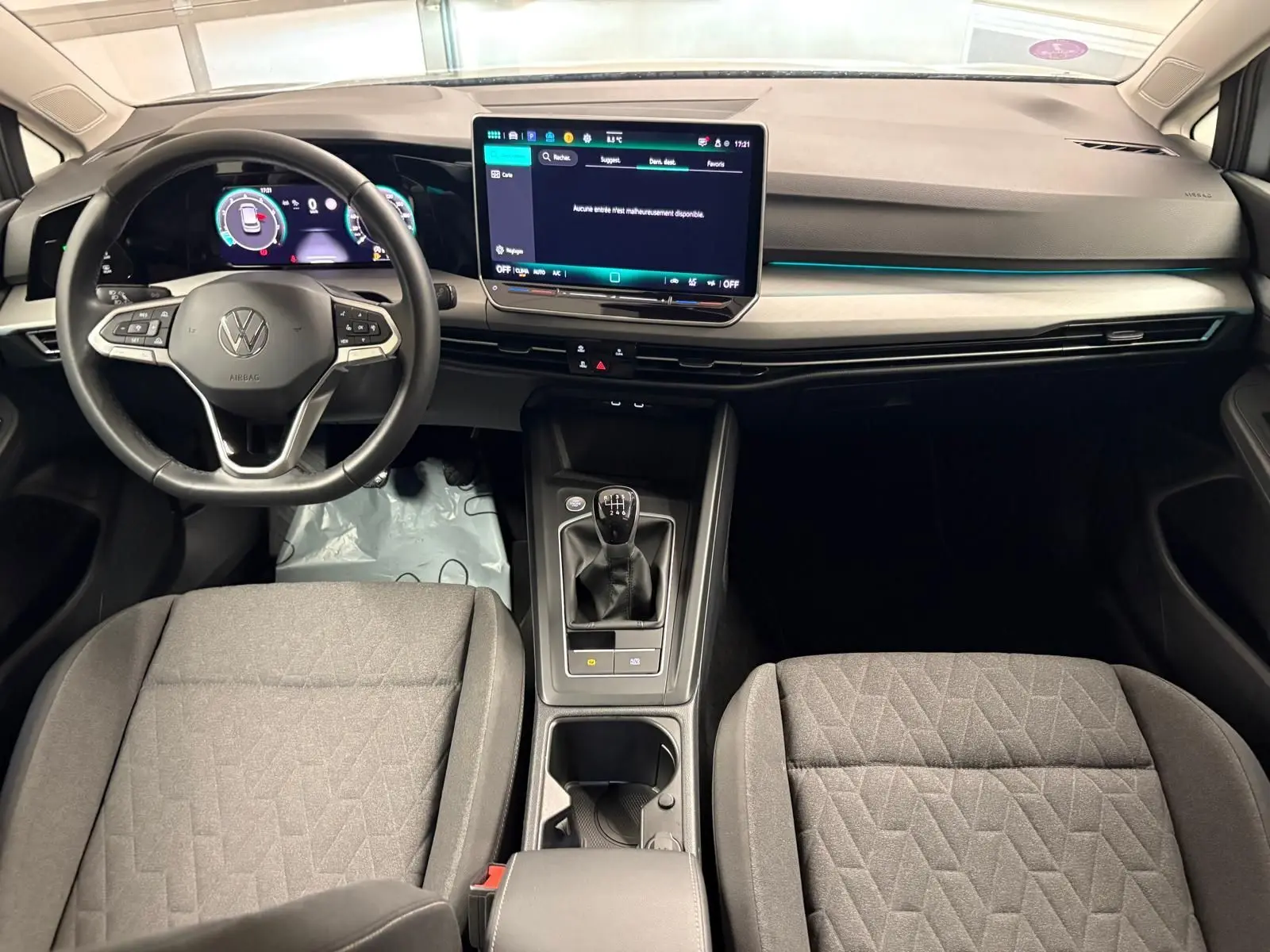 Intérieur de la Volkswagen Golf 1.5 TSI 2025, tableau de bord moderne avec écran tactile et boîte manuelle au centre.