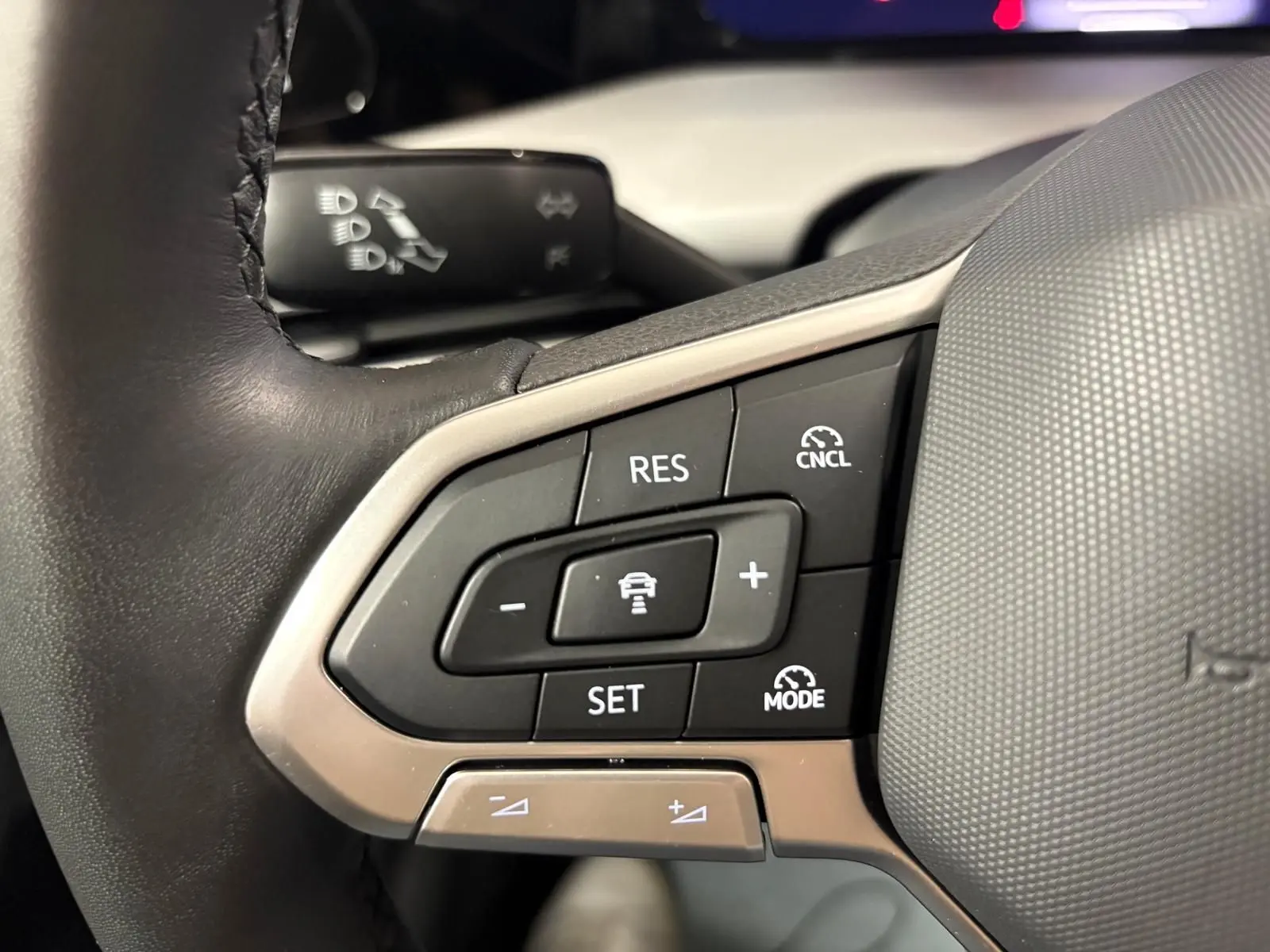 Gros plan sur les commandes du régulateur de vitesse au volant d'une Volkswagen Golf 1.5 TSI 2025.