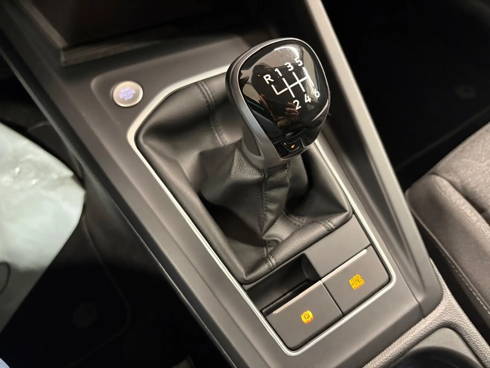 Le levier de vitesses manuel noir de la Volkswagen Golf 1.5 TSI 116 BVM6 VW Edition, vue en gros plan sur la console centrale.