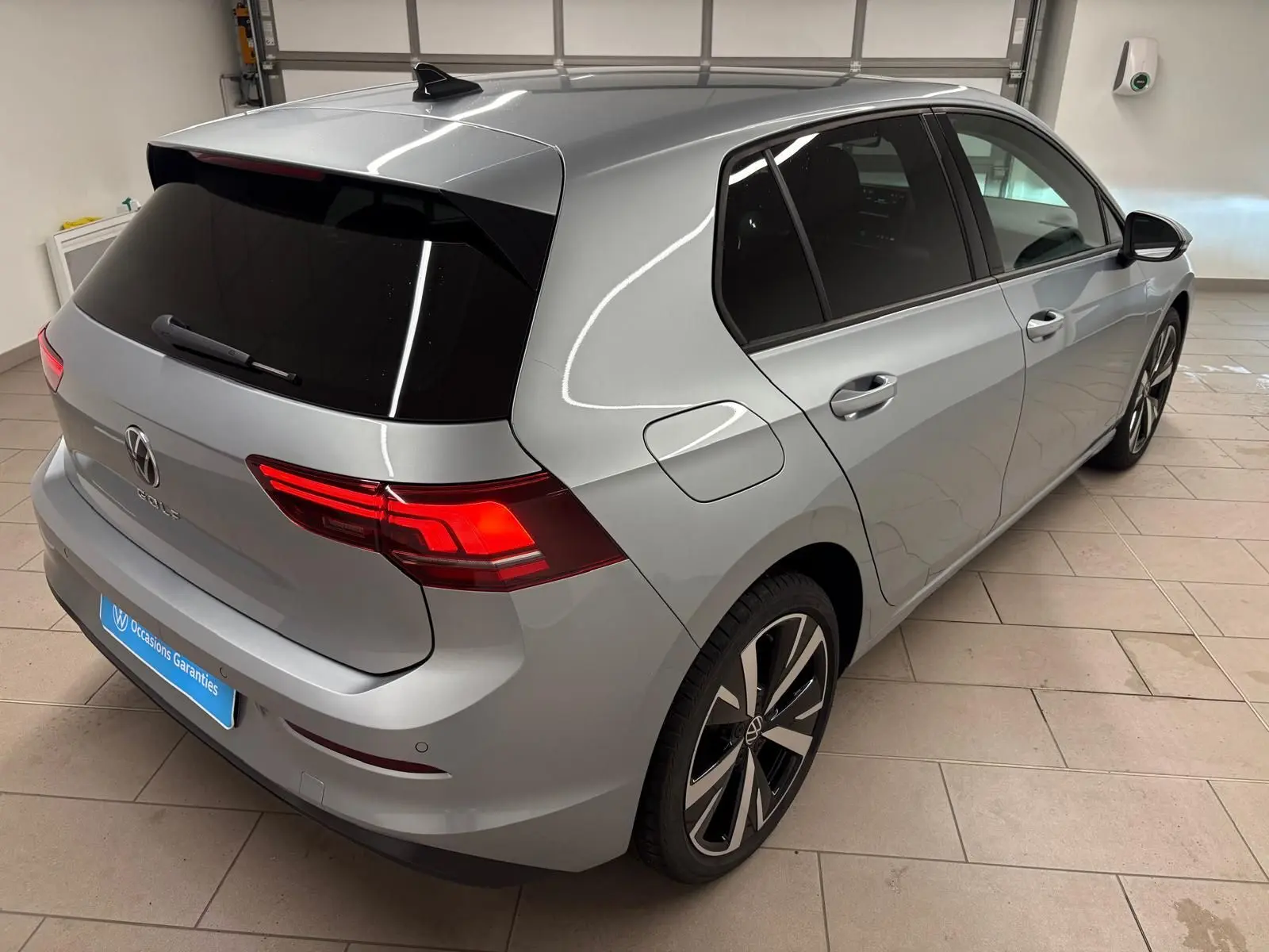 Vue 3/4 arrière droite d'une Volkswagen Golf 2025 argent Dolomite avec jantes alliage léger 18'' Catania.