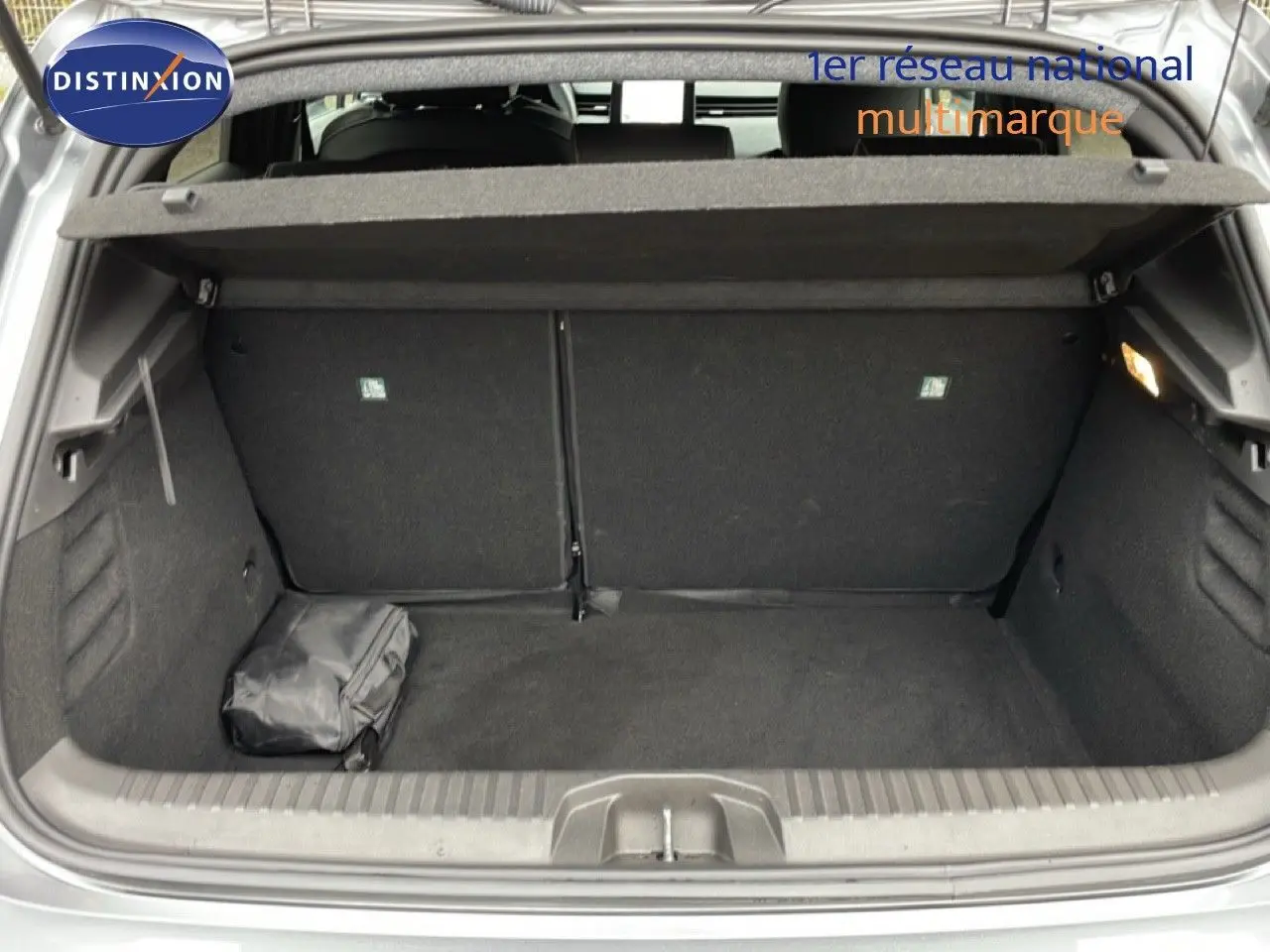 Coffre ouvert de Renault Clio V 1.0 ECO-G 100CH TECHNO gris schiste métal, montrant un espace de rangement propre avec un sac noir.