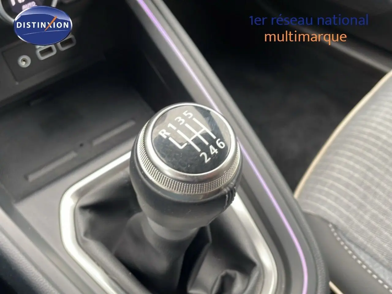 Gros plan sur le levier de vitesses manuel de la Renault Clio 2025, intérieur gris avec surpiqûres et éclairage d'ambiance violet.