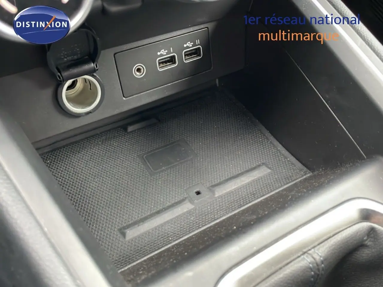 Vue rapprochée de la console centrale de la Renault Clio 2025 gris schiste, montrant prises USB, prise 12V et espace de rangement.