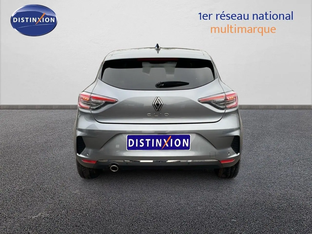 Vue arrière d'une Renault Clio gris schiste métal 2025 avec feux LED et sortie d'échappement visible à gauche.