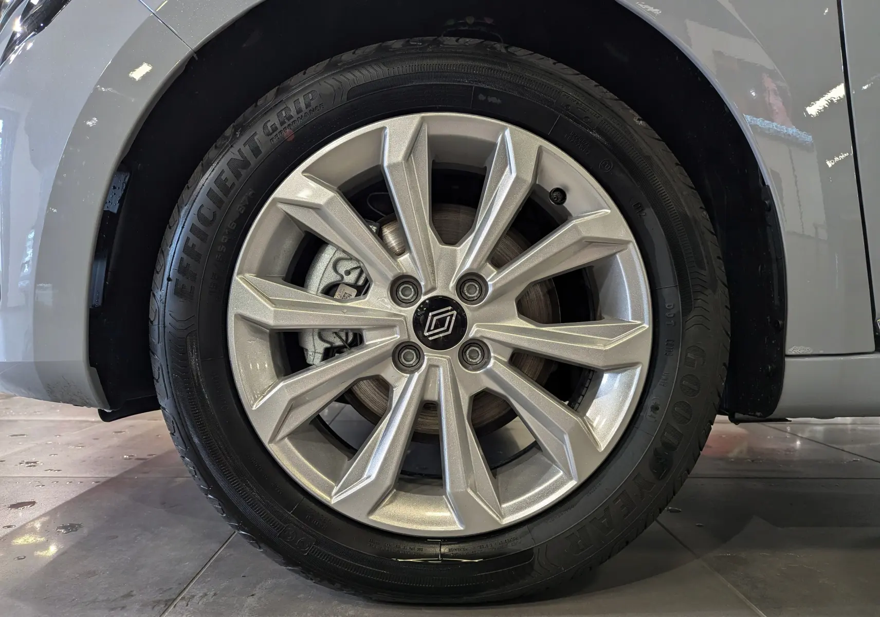 Gros plan sur la roue avant gauche de la Renault Clio V Gris Rafale avec jante alliage argentée et pneu Goodyear.