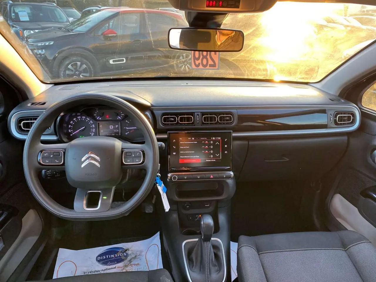 Vue intérieure avant de la Citroën C3 Shine 2023 avec tableau de bord noir et écran tactile central allumé.