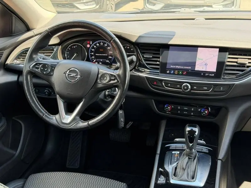 Intérieur de l’Opel Insignia Grand Sport 2021 vu de face, tableau de bord noir avec écran tactile et volant cuir multifonction.
