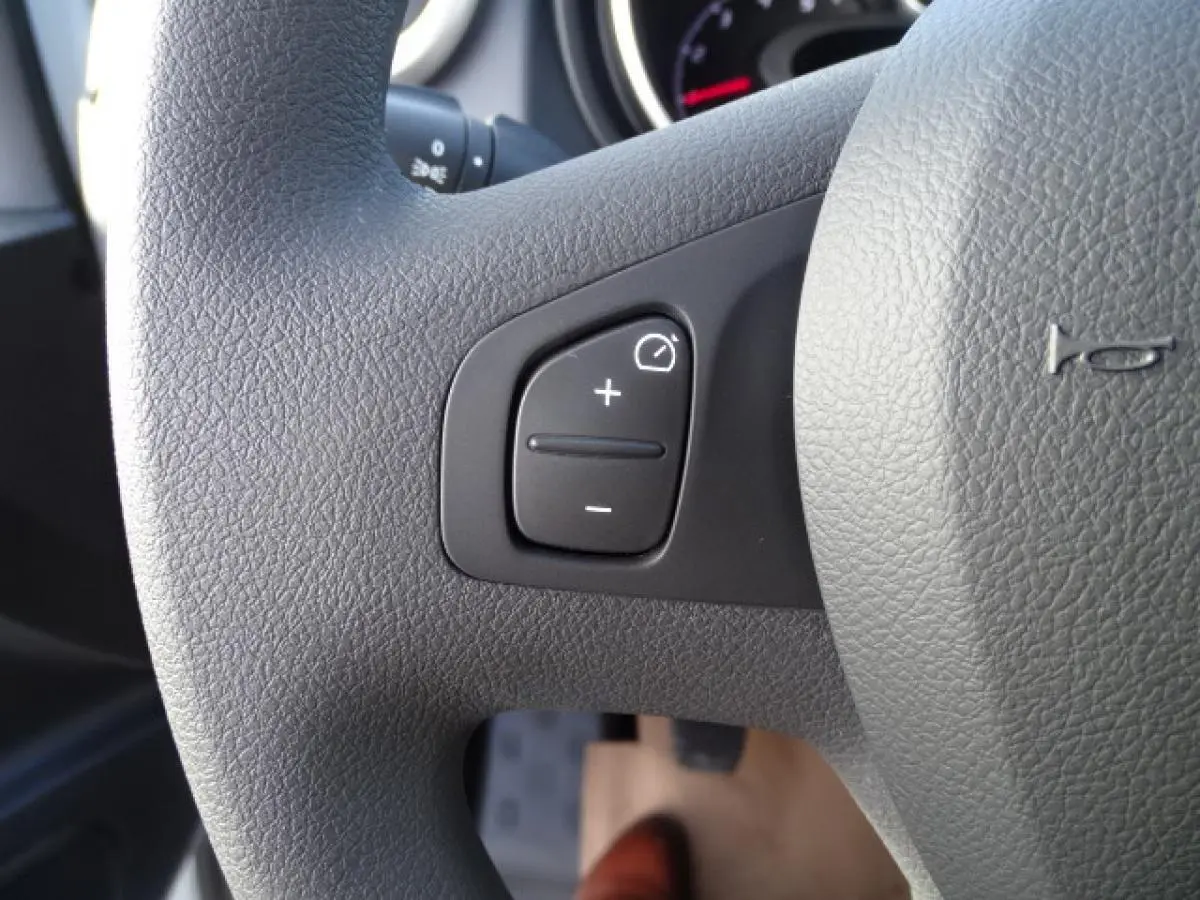 Gros plan sur le volant gris du Fiat Talento Fourgon 2020, montrant les commandes de régulation d’éclairage.