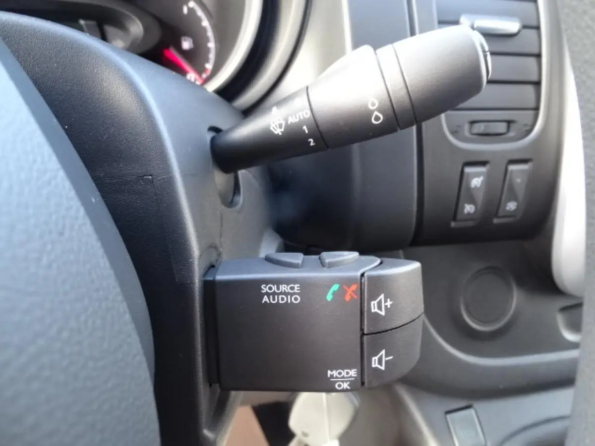 Gros plan sur la commande audio au volant du FIAT Talento Fourgon blanc, côté gauche du tableau de bord.