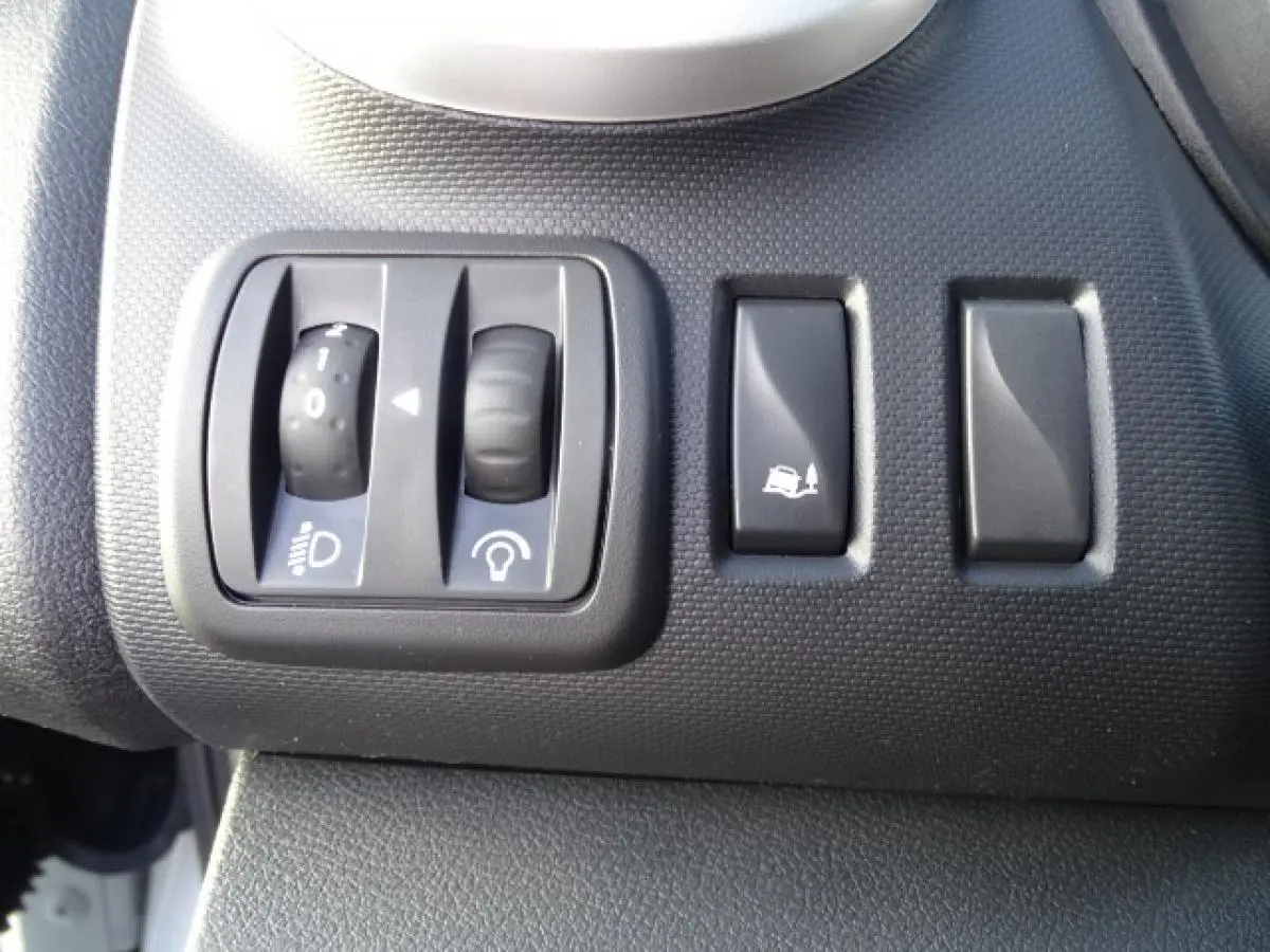 Gros plan sur les commandes de réglage des phares et de l’aide à la montée dans un Fiat Talento Fourgon blanc.