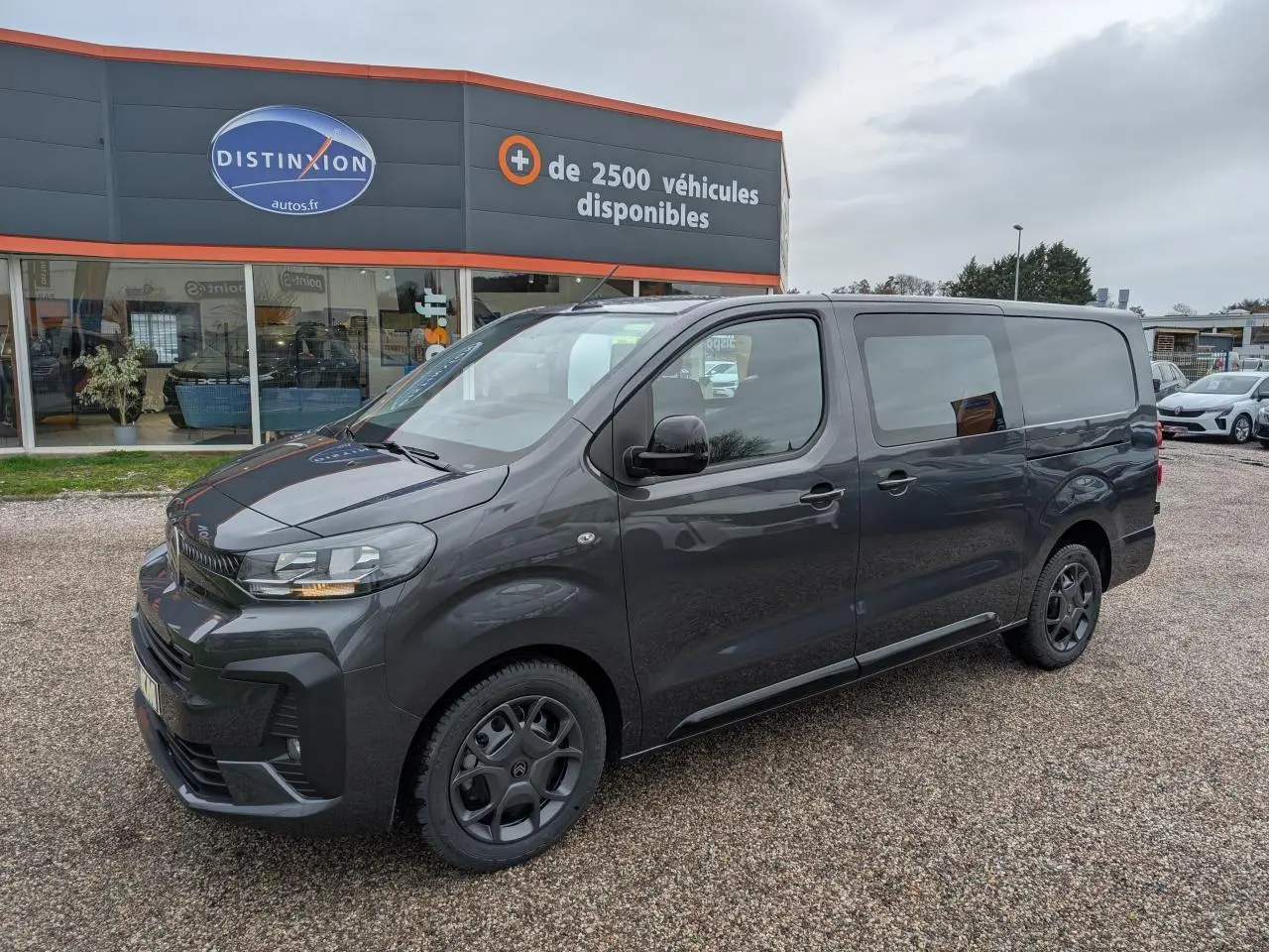 Vue 3/4 avant droit d’un Citroën Jumpy XL gris métallisé avec baguettes latérales noires et jantes tôles peintes.