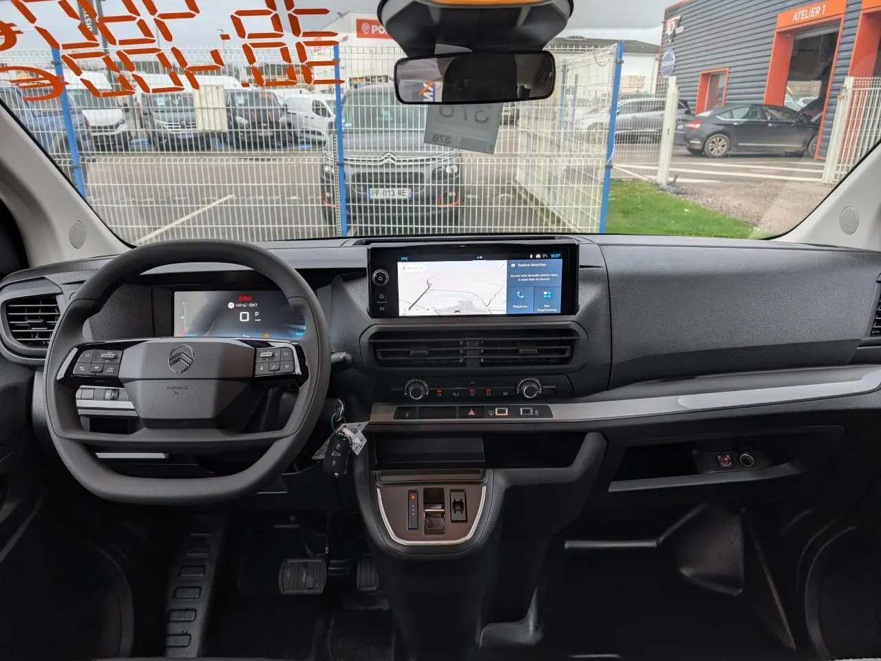 Vue intérieure avant du tableau de bord gris foncé du Citroën Jumpy XL 2025 avec écran tactile et volant multifonction.