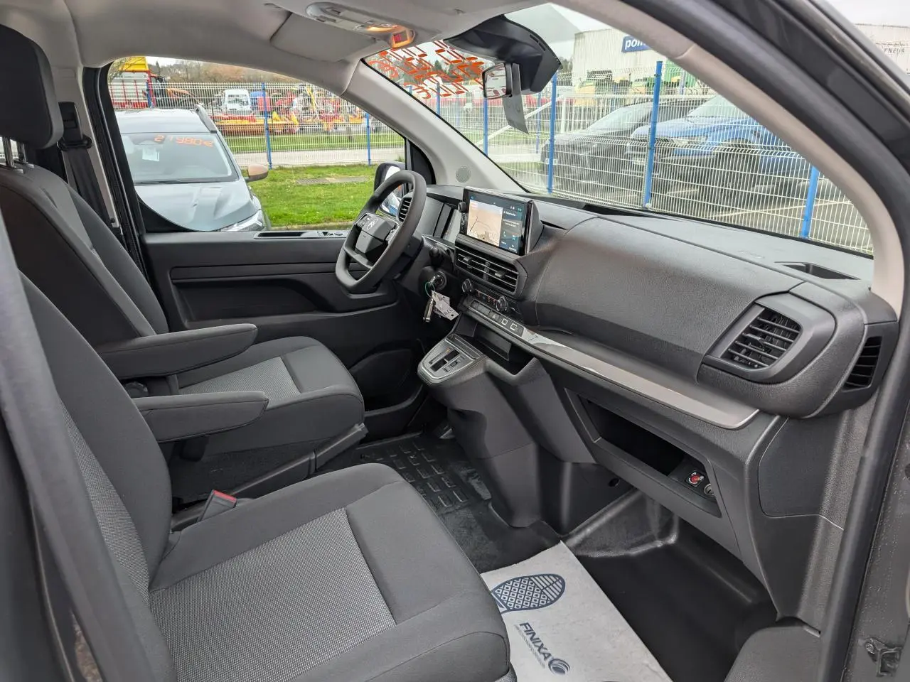 Vue intérieure côté droit du poste de conduite du Citroën Jumpy gris 2025 avec tableau de bord moderne et sièges tissu bi-ton.