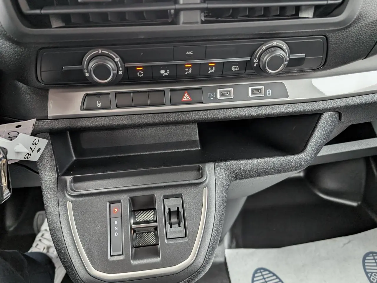 Vue rapprochée de la console centrale noire du Citroën Jumpy gris avec commandes de climatisation et boîte automatique.