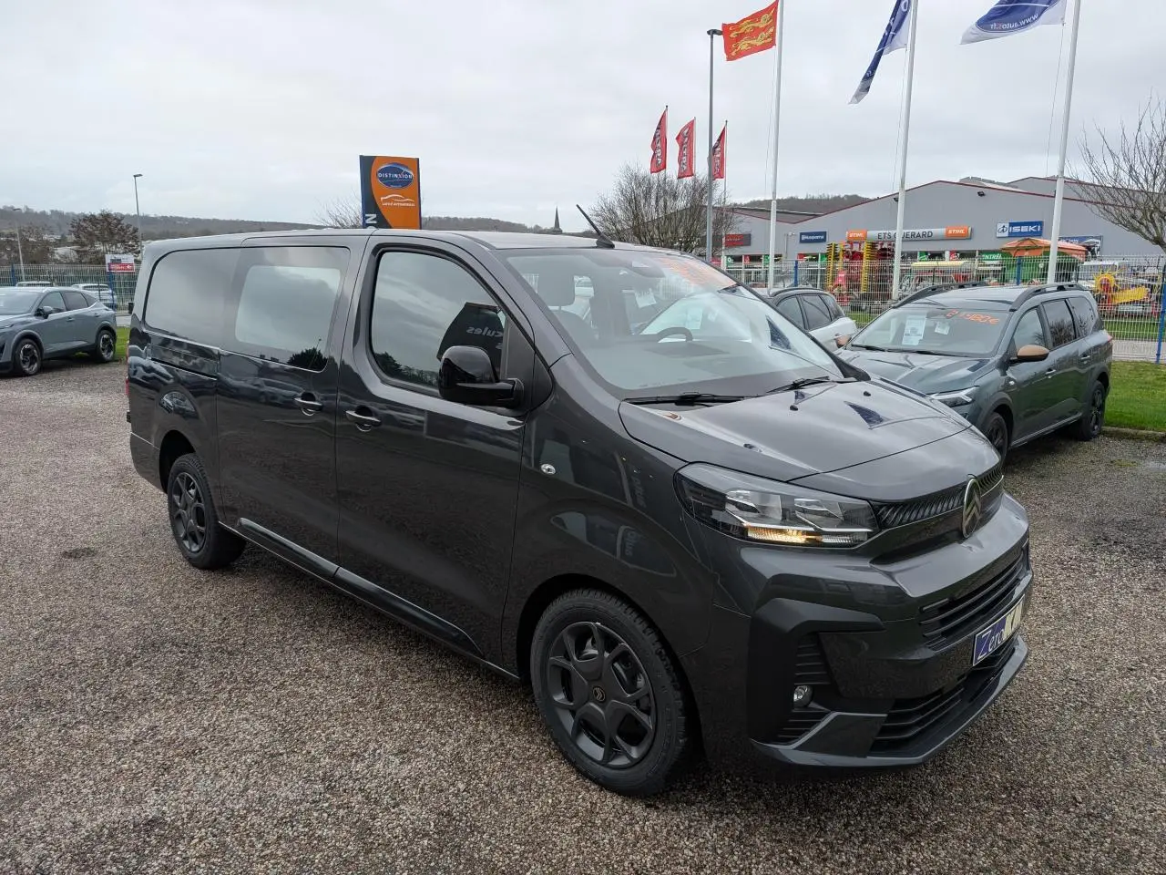 Vue 3/4 avant droit d’un Citroën Jumpy XL gris métallisé avec boucliers couleur carrosserie et coques de rétroviseurs noires.