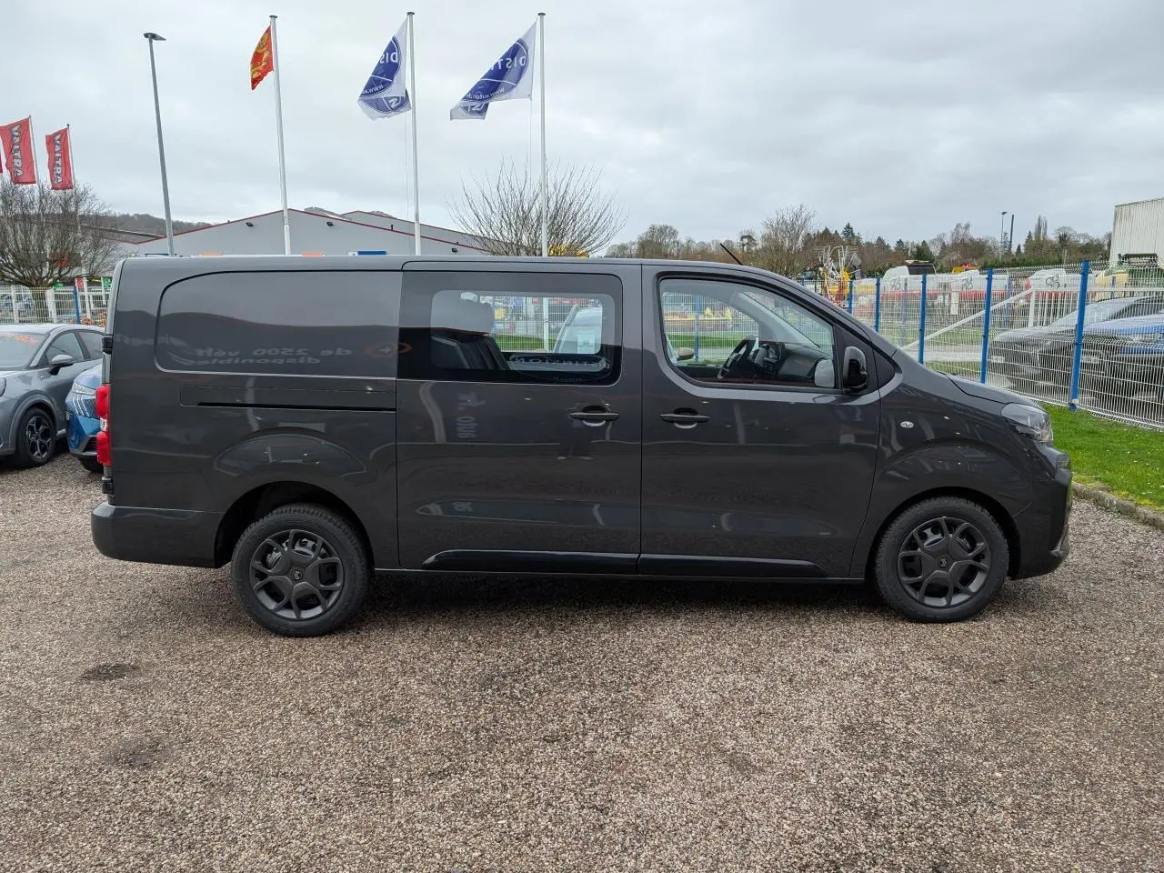 Vue de profil côté droit d’un Citroën Jumpy XL gris métallisé avec cabine approfondie et roues tôles noires.