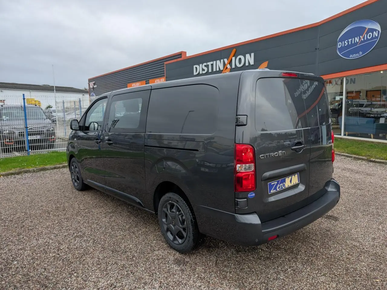 Vue 3/4 arrière droite d’un Citroën Jumpy gris avec boucliers teintés et jantes tôles noires.