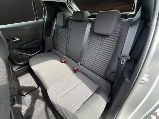 Banquette arrière grise foncée de la Peugeot 208 100CH S&S Active 2024, vue côté droit avec ceintures et appuie-têtes.