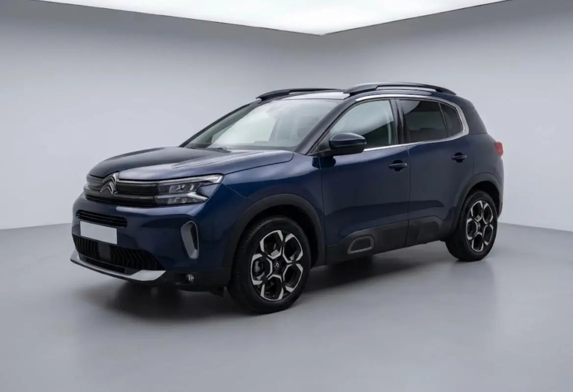 Citroën C5 Aircross hybride 2024 bleu foncé, vue 3/4 avant droit avec jantes au design hexagonal distinctif.