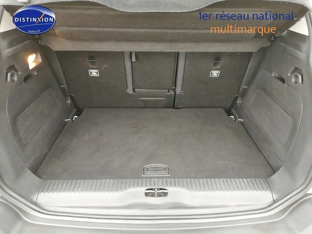 Coffre ouvert d'un Citroën C3 Aircross blanc polar, vue intérieure montrant l'espace de chargement vide et les dossiers arrière.