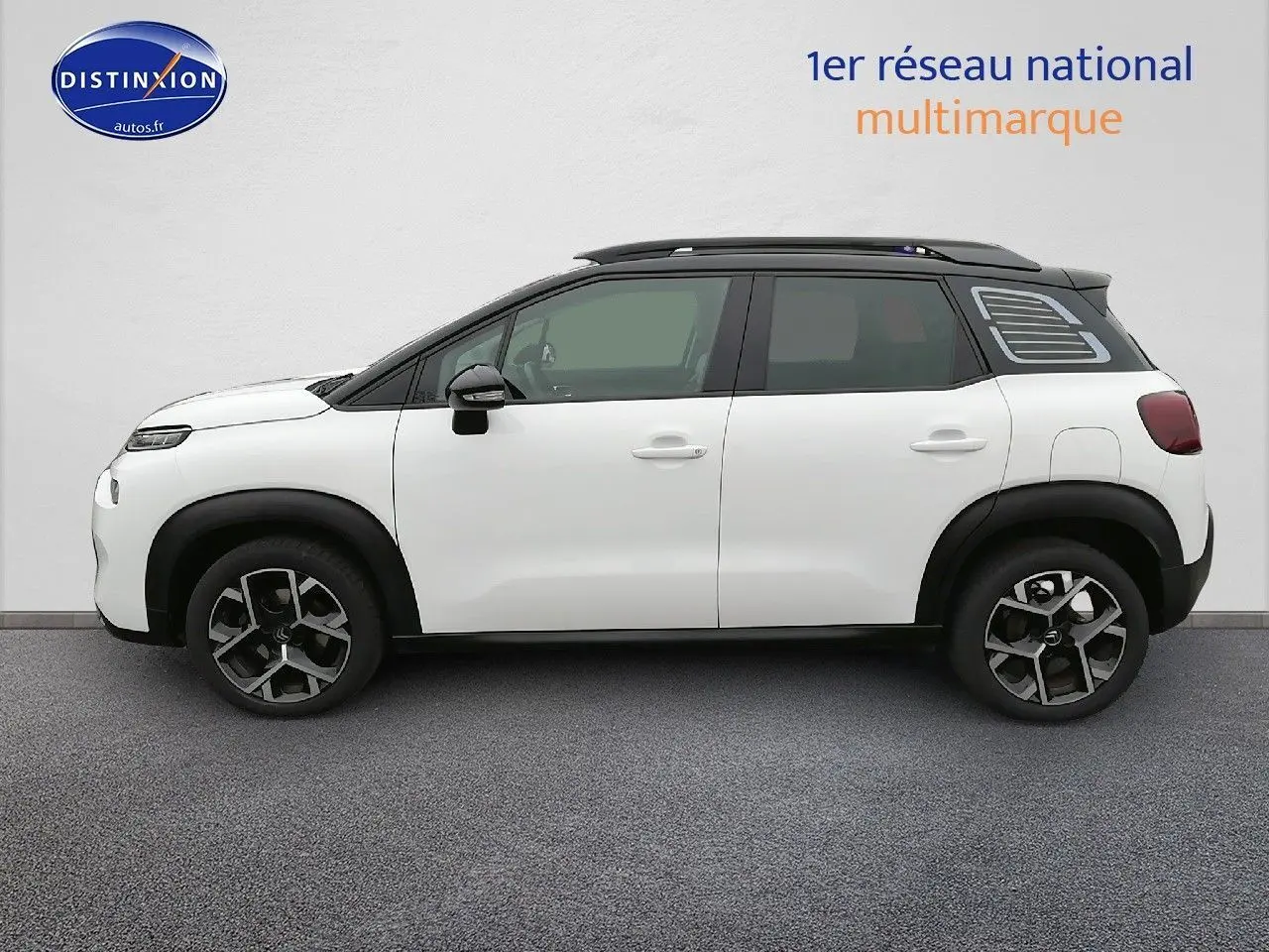 Profil gauche d'un Citroën C3 Aircross blanc polar avec toit noir et jantes alliage bicolores.