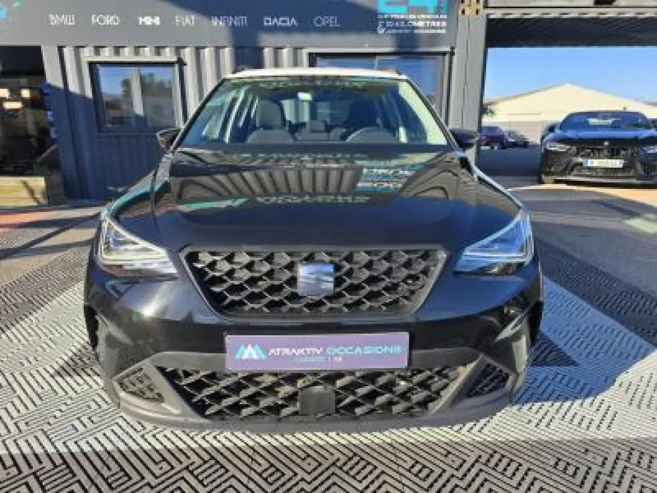 Vue frontale d'un SEAT Arona noir minuit avec calandre hexagonale et phares LED marqués.