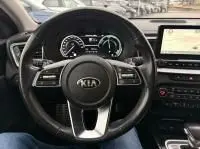 Vue intérieure centrée sur le volant du KIA Xceed blanc 1.6 GDI hybride rechargeable, tableau de bord et écran tactile visibles.