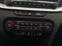 Gros plan sur la console centrale du Kia Xceed blanc 2021, montrant les commandes climatisation et écran tactile.