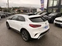 Vue 3/4 arrière droite d’un KIA Xceed blanc 1.6 GDI hybride rechargeable 2021, avec toit noir et jantes alliage visibles.