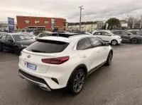 Vue 3/4 arrière droite d’un KIA Xceed blanc hybride rechargeable 2021, avec toit noir et jantes alliage sombres.