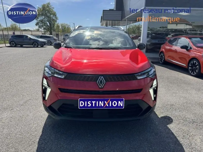 Vue avant d'un Renault Captur rouge flamme 2025 avec calandre noire et feux LED verticaux distinctifs.