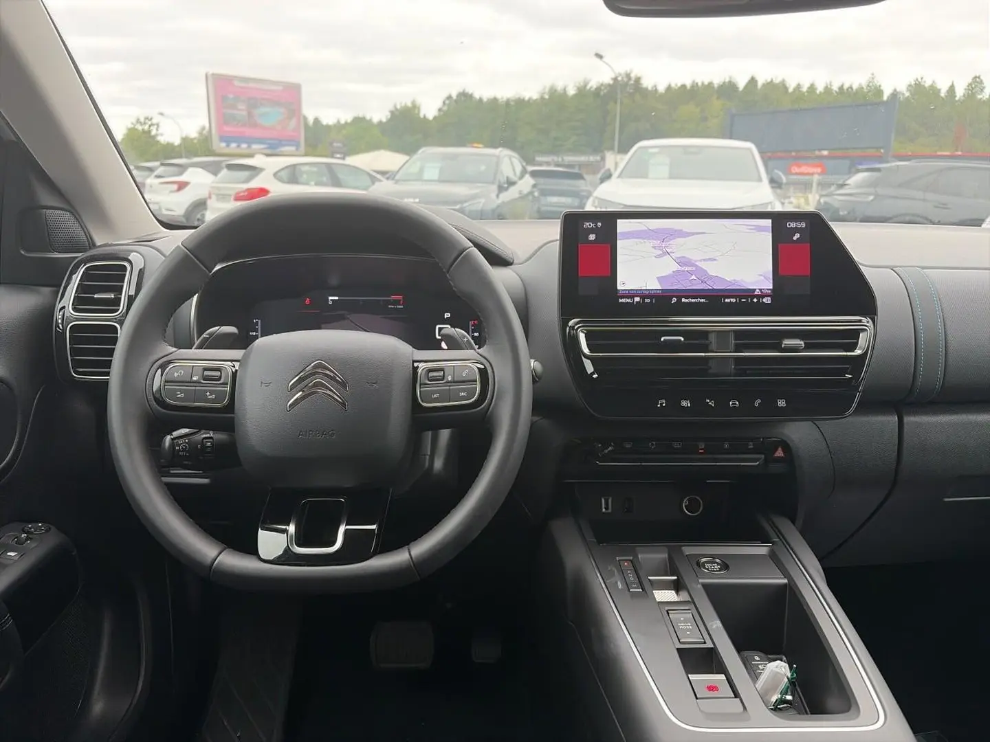 Vue intérieure avant du poste de conduite du Citroën C5 Aircross blanc avec écran tactile et volant multifonction noir.