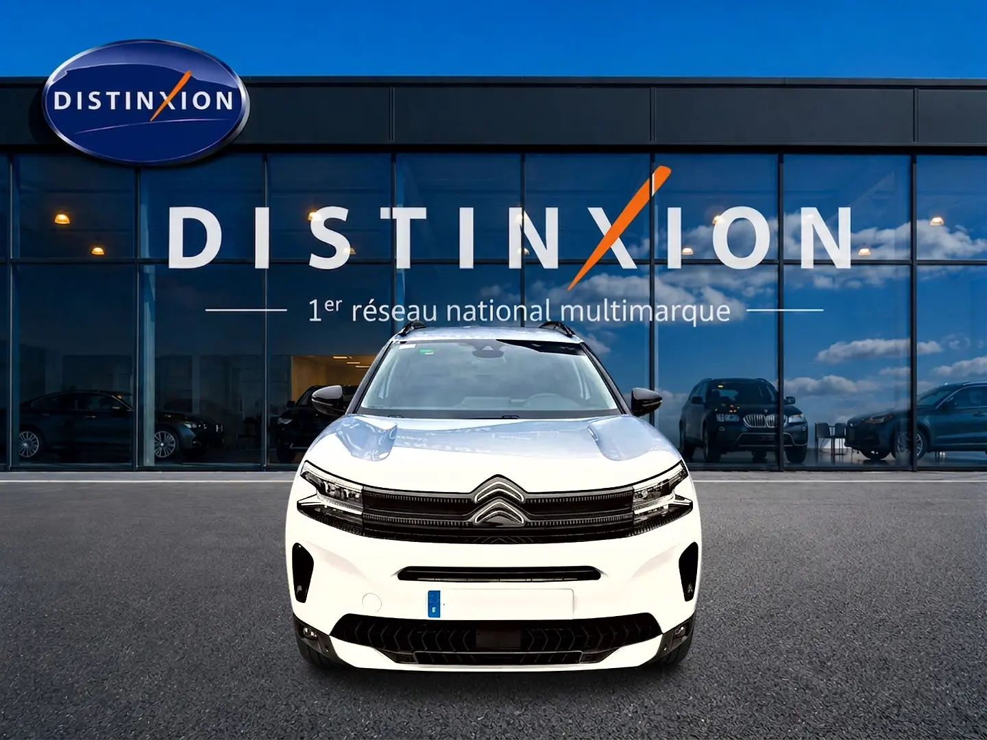 Citroën C5 Aircross blanc vue de face devant une vitrine avec logo Distinxion en arrière-plan.