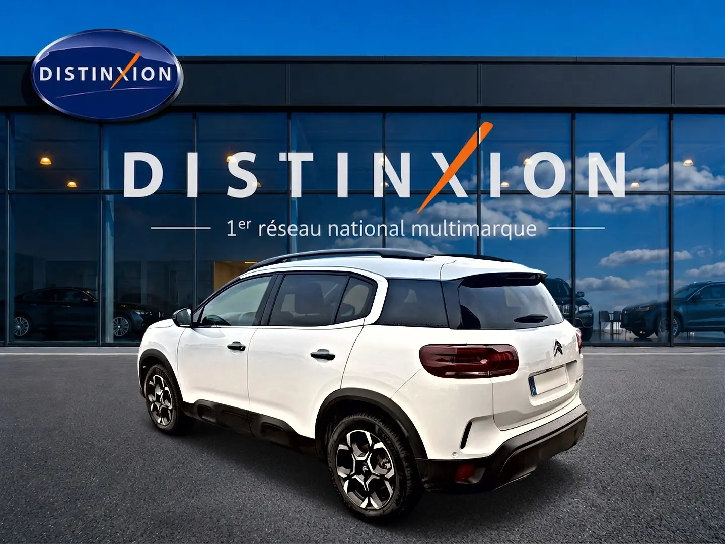 Citroën C5 Aircross blanc vue 3/4 arrière droit, avec toit noir et jantes alliage distinctives, devant showroom Distinxion.