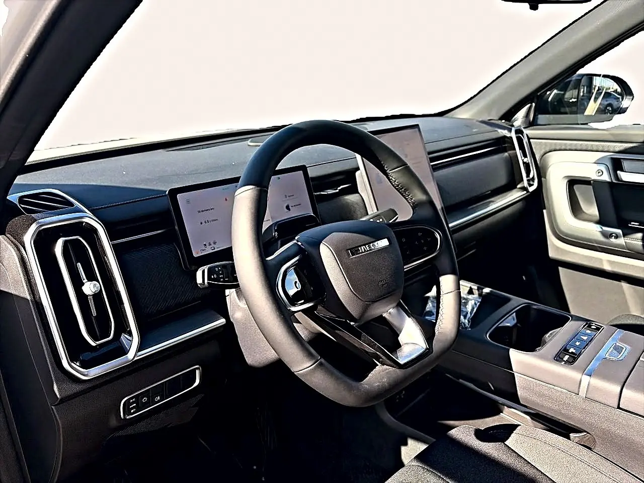 Vue intérieure côté conducteur du JAECOO J7 1.5 tgdi 224 select, volant multifonction noir et écran tactile double.