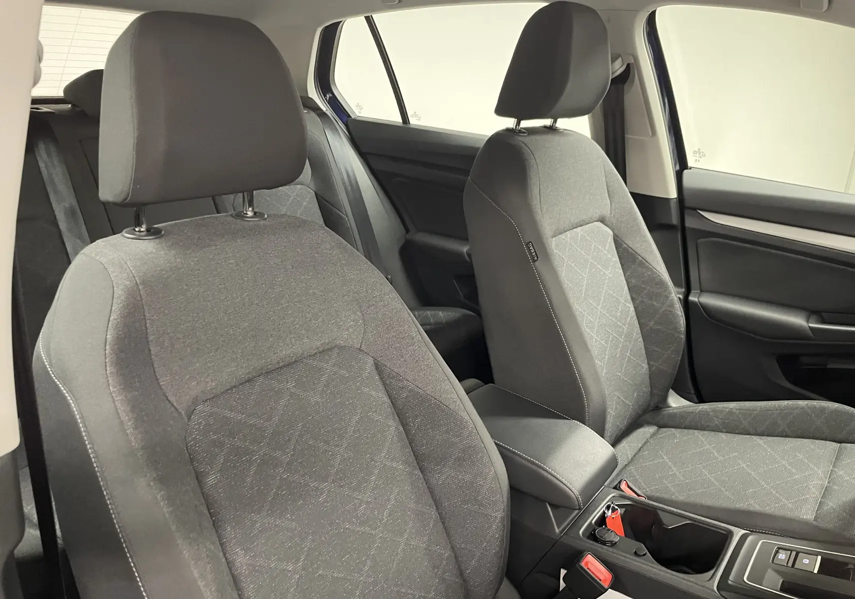Vue intérieure des sièges avant en tissu gris avec coutures contrastées de la Volkswagen Golf 2023 côté droit.