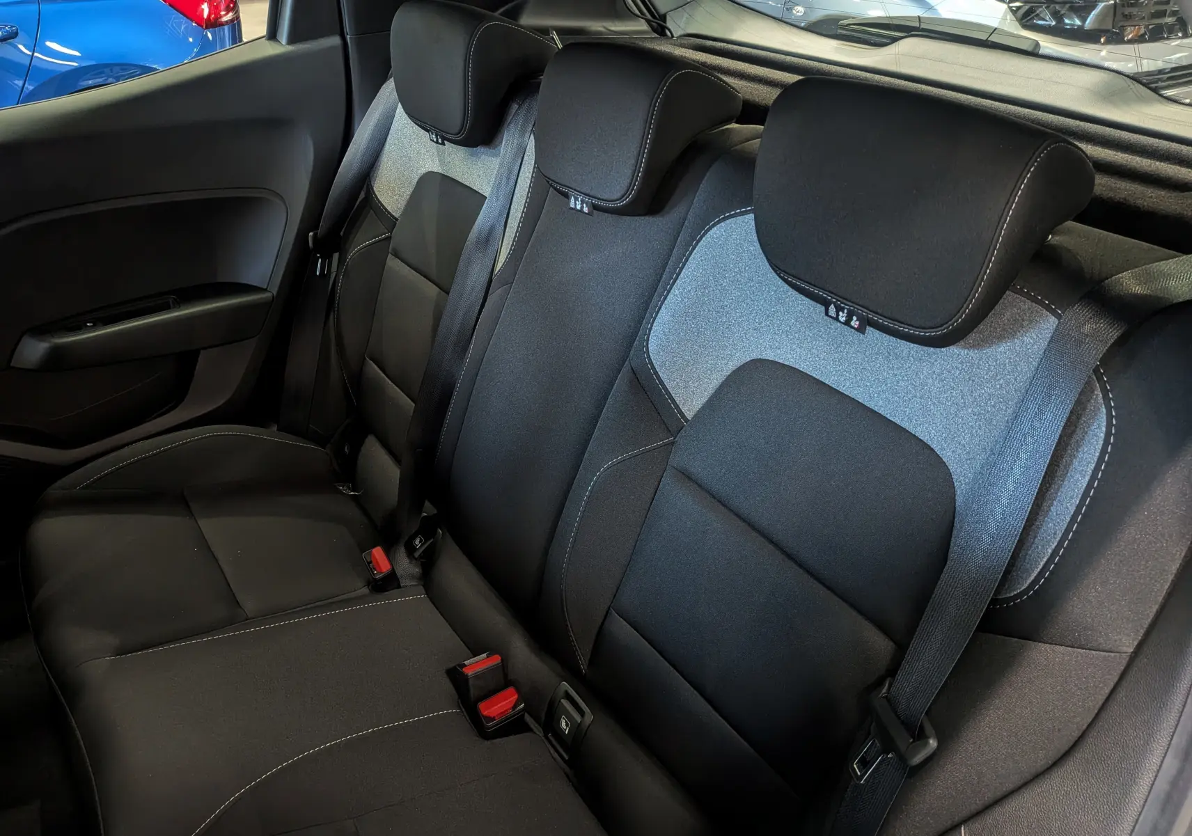 Vue intérieure des sièges arrière en tissu noir et gris clair de la Renault Clio V 2025, côté droit visible.