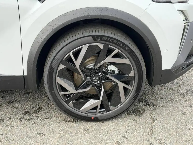 Gros plan sur la roue avant droite du Renault Captur 2026 blanc nacré avec jante alu noire et argentée au design géométrique.