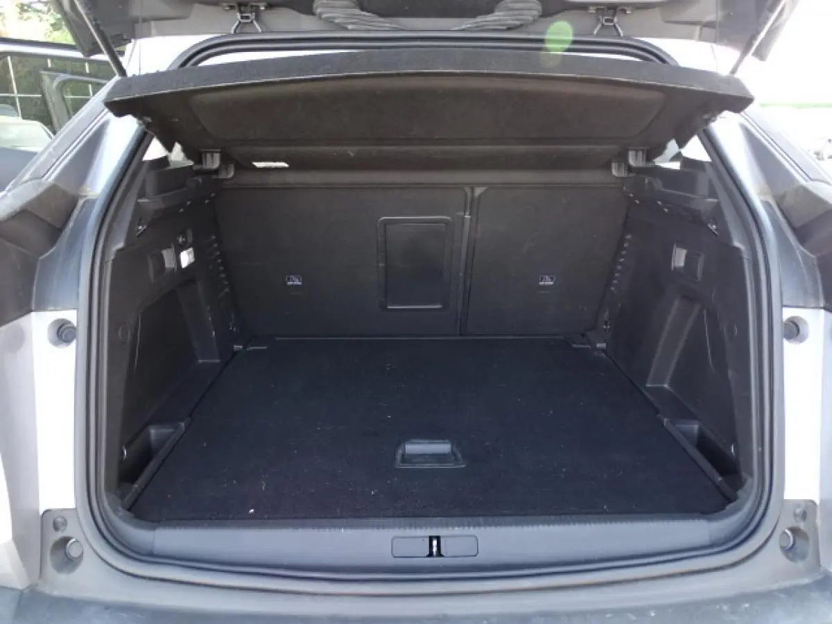 Coffre ouvert vu de l'arrière d'un Peugeot 3008 gris Artense, montrant l'espace de chargement vide et la tablette cache-bagages.