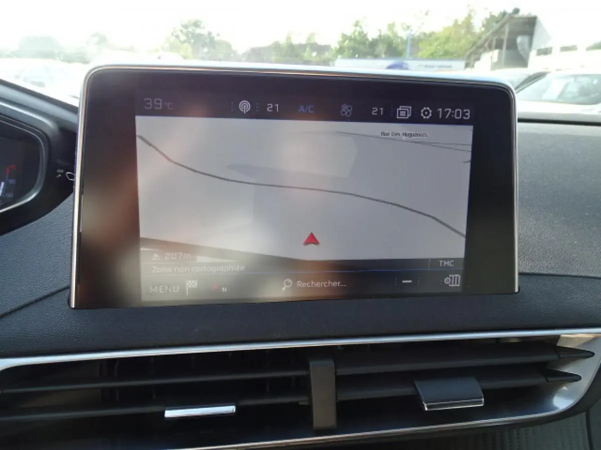 Vue rapprochée de l'écran tactile central du Peugeot 3008 gris Artense, affichant la navigation GPS en extérieur.