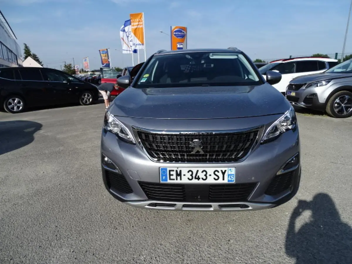 Vue frontale d'un Peugeot 3008 gris Artense métallisé, avec calandre noire et plaques d'immatriculation visibles.