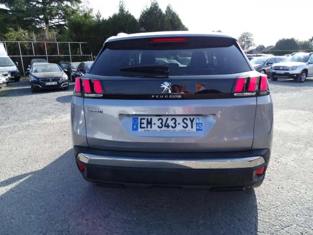 Vue arrière d’un Peugeot 3008 gris Artense avec feux arrière à trois griffes et bandeau noir brillant.
