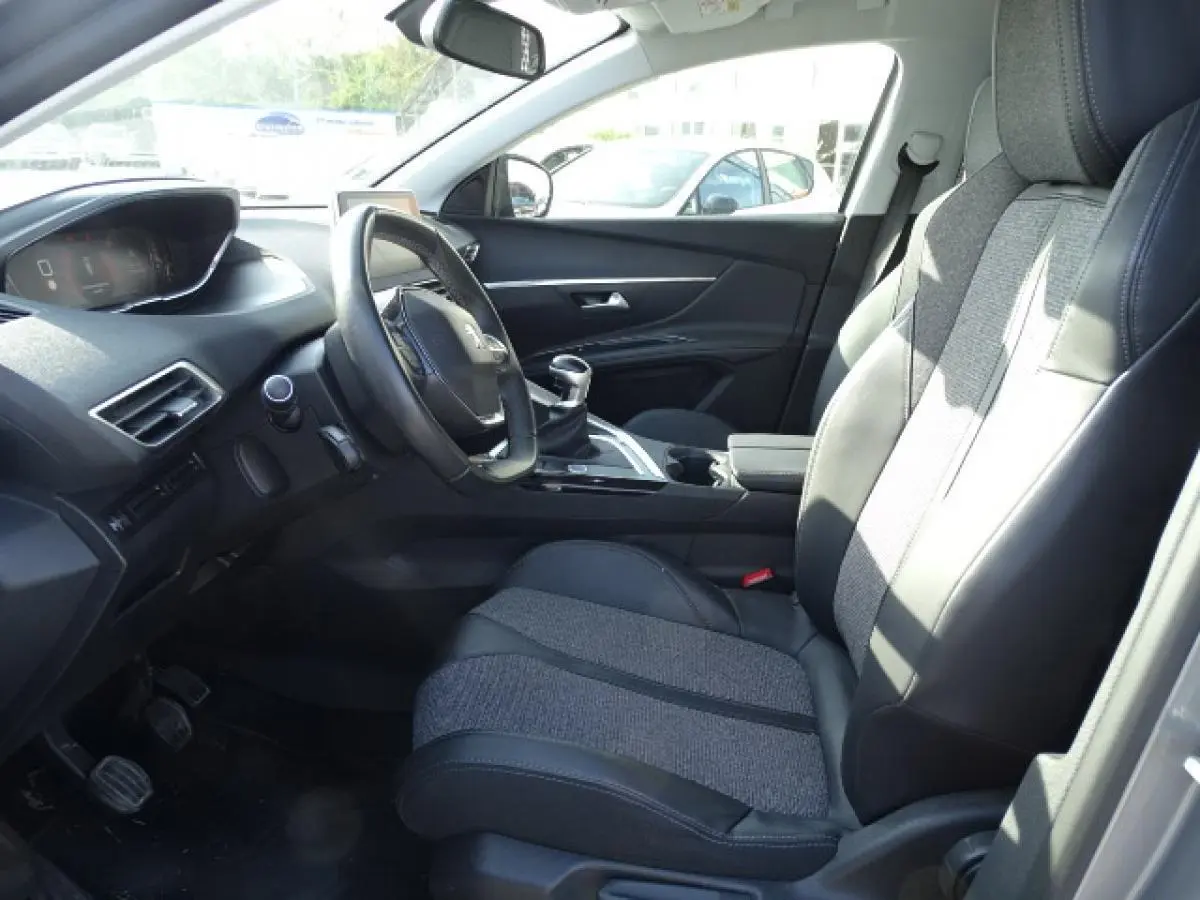 Vue intérieure côté conducteur du Peugeot 3008 2017, sièges bi-matière noirs et gris avec volant compact et levier de vitesse manuel.